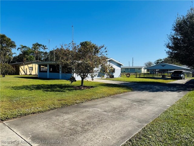 view of front of property with a front yard and a carport