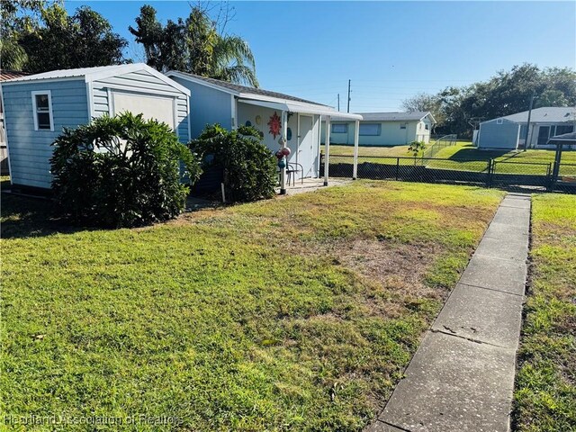 view of front of house with a front yard and a shed