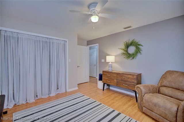 living area with ceiling fan and light hardwood / wood-style floors