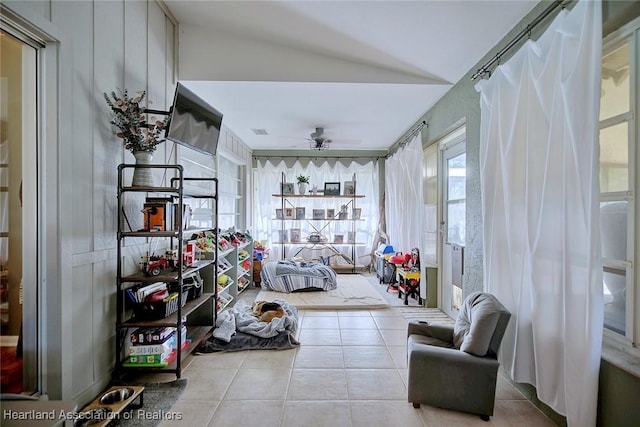 sitting room featuring light tile patterned flooring, vaulted ceiling, and ceiling fan