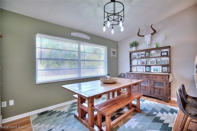 dining area featuring lofted ceiling, plenty of natural light, and wood-type flooring