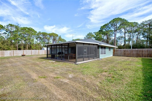 rear view of property featuring a lawn and a sunroom