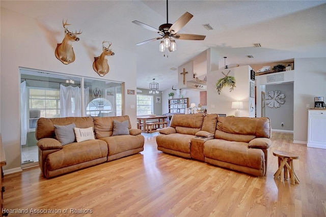 living room with high vaulted ceiling, ceiling fan, and light wood-type flooring