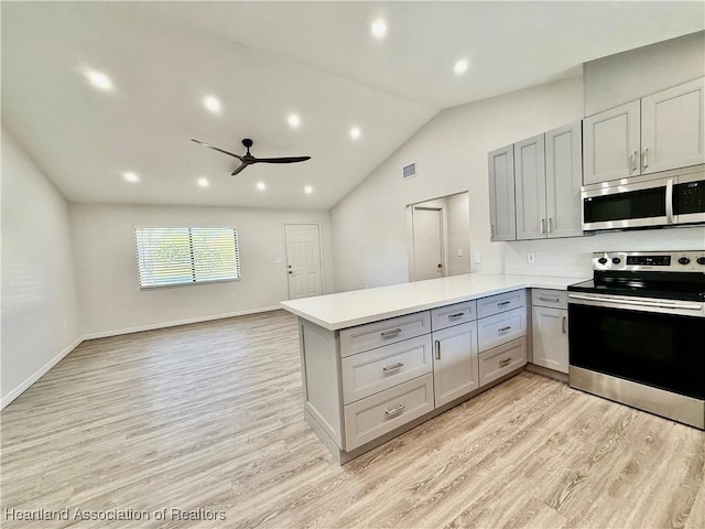 kitchen with stainless steel appliances, kitchen peninsula, light hardwood / wood-style floors, and gray cabinetry