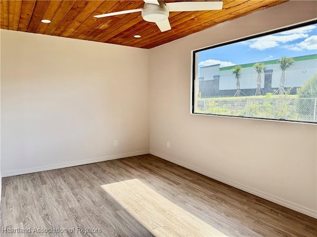 empty room with ceiling fan, light hardwood / wood-style flooring, and wooden ceiling