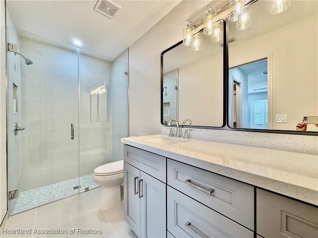 bathroom featuring vanity, a textured ceiling, tile patterned floors, toilet, and walk in shower