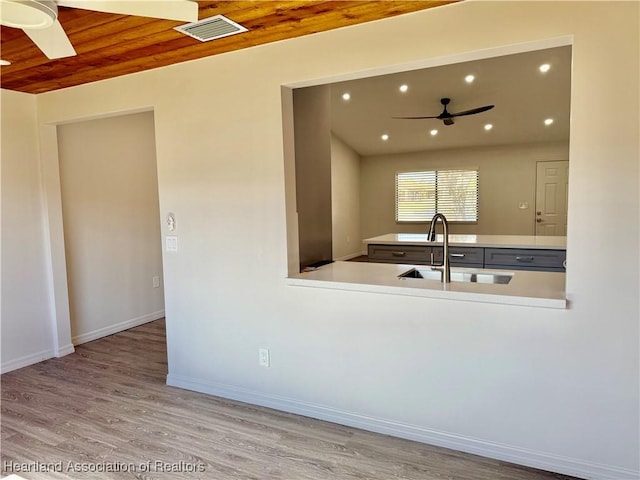 kitchen featuring sink, wood ceiling, ceiling fan, and light hardwood / wood-style flooring