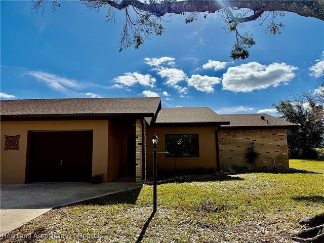 ranch-style home with a garage and a front lawn