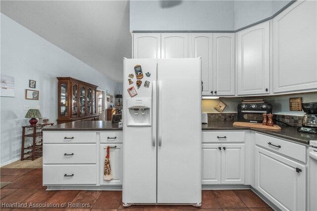 3534 Tubbs Rd, Sebring, FL 33870 - kitchen featuring white fridge with ice dispenser, dark countertops, and white cabinets