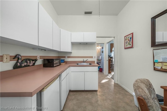 kitchen with visible vents, a sink, white cabinetry, and white dishwasher