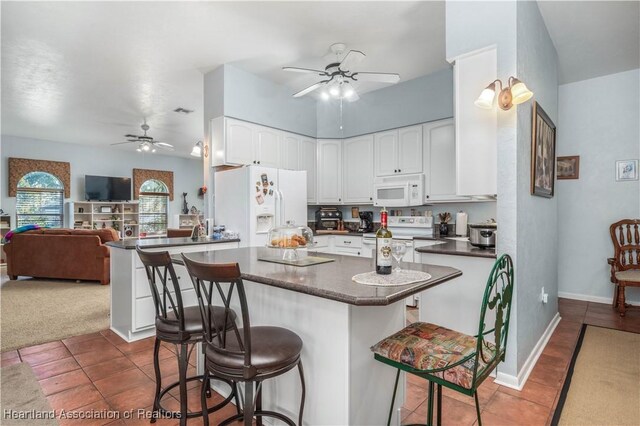 3534 Tubbs Rd, Sebring, FL 33870 - kitchen with white appliances, a ceiling fan, dark countertops, and a breakfast bar