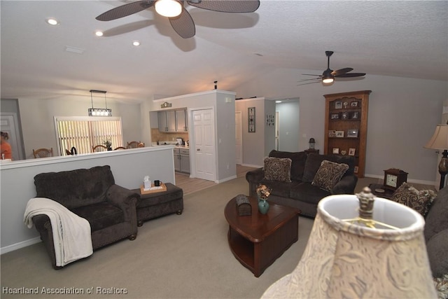 carpeted living room with ceiling fan and lofted ceiling