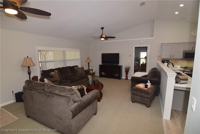 living room featuring ceiling fan and vaulted ceiling