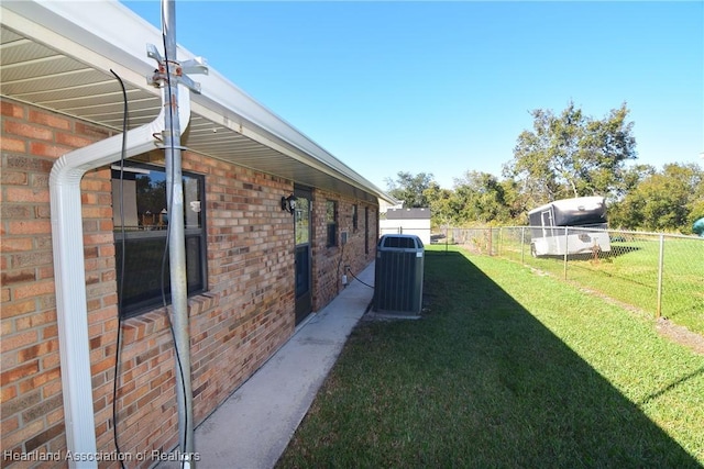 view of side of home featuring a yard and central air condition unit