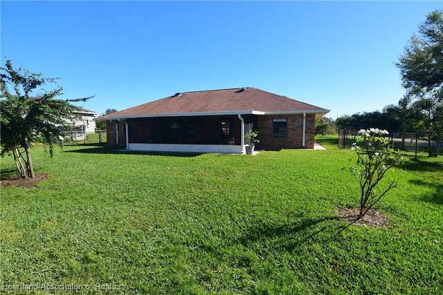 back of property featuring a sunroom and a yard