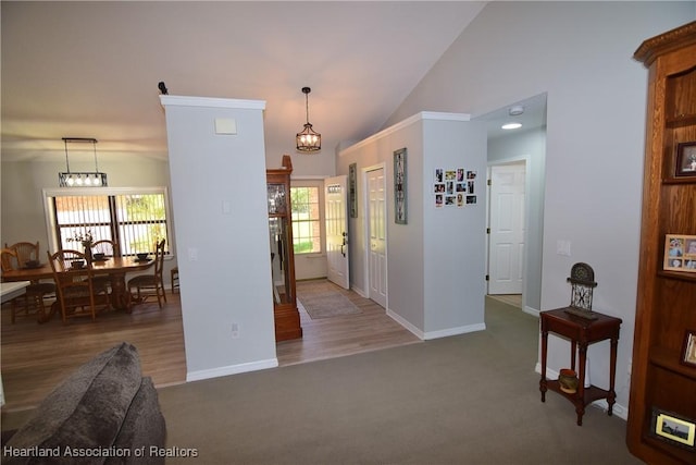 carpeted entryway featuring a chandelier and lofted ceiling