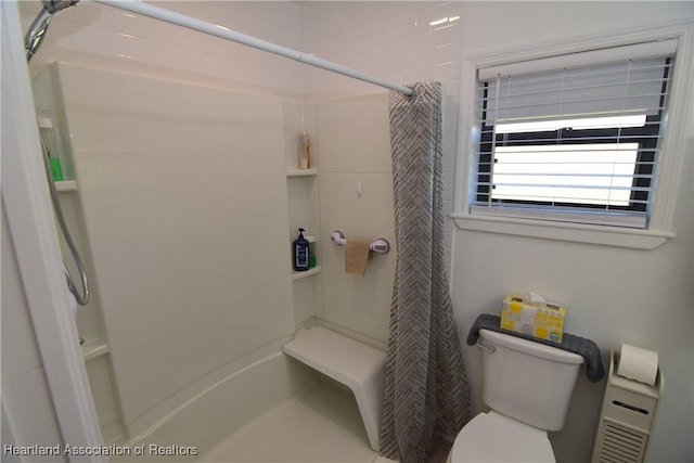 bathroom with a shower with curtain and toilet