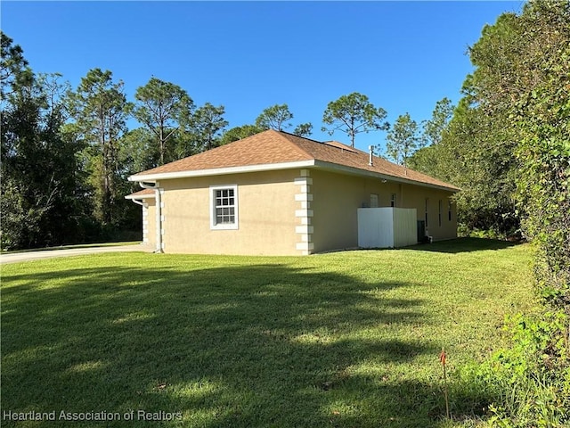 view of side of home with a yard