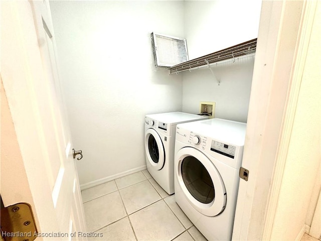 washroom with washing machine and clothes dryer and light tile patterned floors