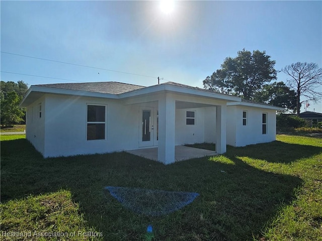 2859 N Lancaster Rd, Avon Park, FL 33825 - rear view of house with a lawn, a carport, a patio area, and stucco siding