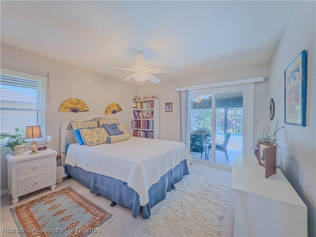 carpeted bedroom featuring a ceiling fan, access to outside, a textured ceiling, and multiple windows