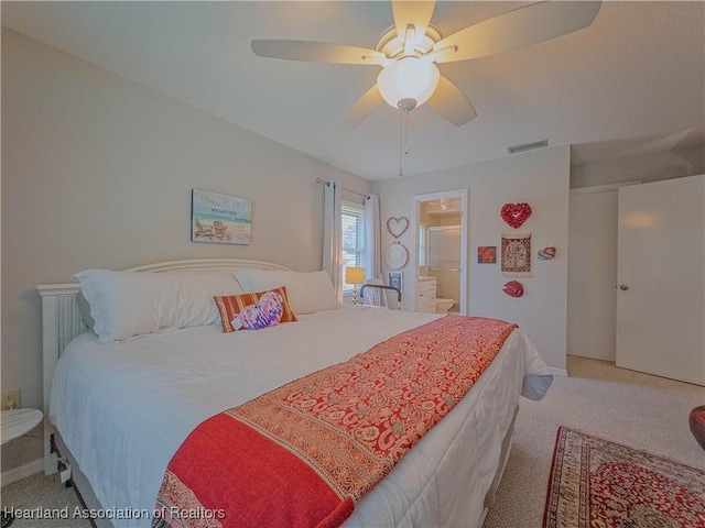 bedroom featuring visible vents, baseboards, carpet, a ceiling fan, and ensuite bath