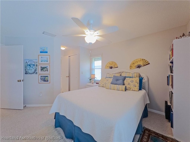 carpeted bedroom with visible vents, ceiling fan, and baseboards