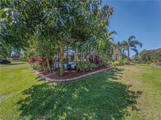 view of yard with a lanai and a swimming pool