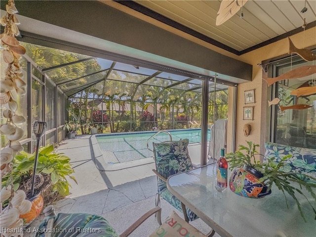 view of patio / terrace featuring a lanai, a ceiling fan, and an outdoor pool
