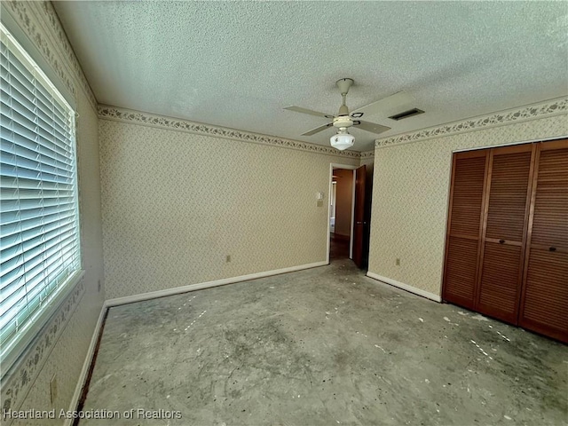 unfurnished bedroom featuring visible vents, a closet, baseboards, a textured ceiling, and a ceiling fan