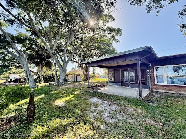 view of yard with an outdoor structure, a patio, and a shed