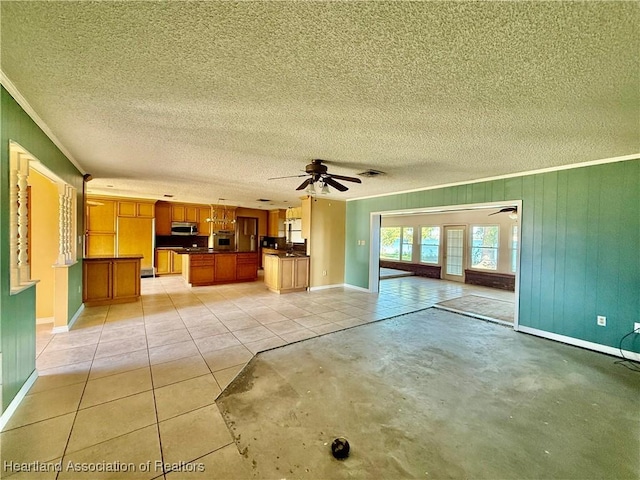 unfurnished living room featuring a ceiling fan, a textured ceiling, ornamental molding, and baseboards