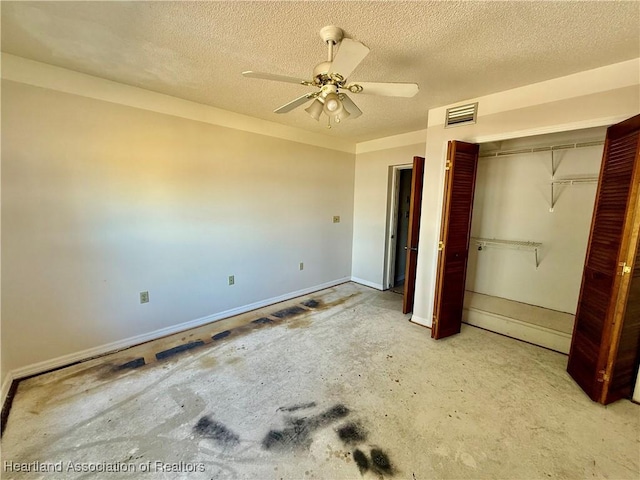 unfurnished bedroom with baseboards, a closet, a textured ceiling, and visible vents