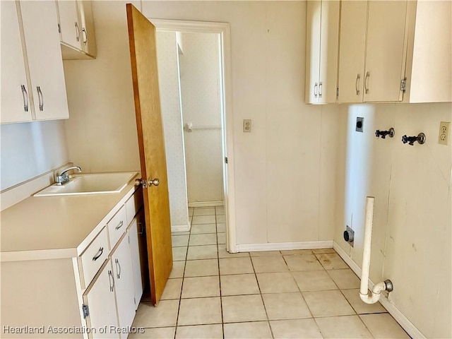 washroom with cabinet space, washer hookup, a sink, electric dryer hookup, and light tile patterned floors