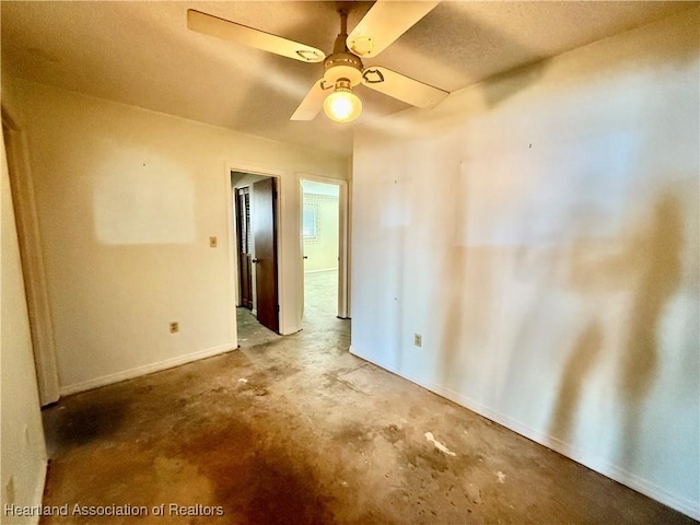empty room with baseboards, concrete floors, and ceiling fan