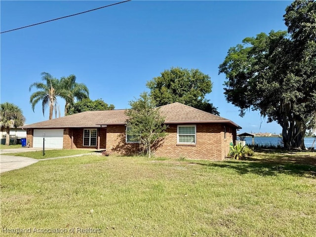 single story home featuring an attached garage, brick siding, driveway, and a front yard