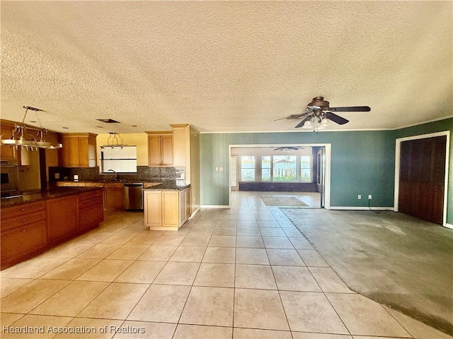 kitchen featuring light tile patterned flooring, dark countertops, a sink, dishwasher, and open floor plan