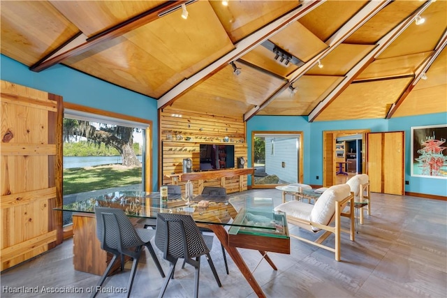 dining area with lofted ceiling, track lighting, wooden walls, and wood ceiling