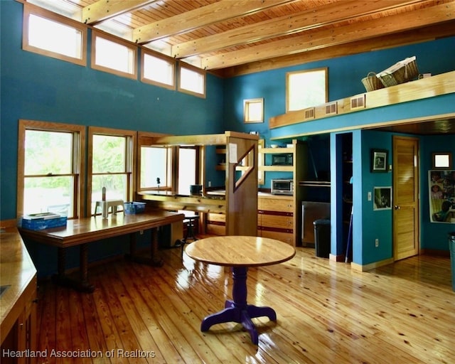 miscellaneous room with beamed ceiling, a towering ceiling, hardwood / wood-style flooring, and wooden ceiling