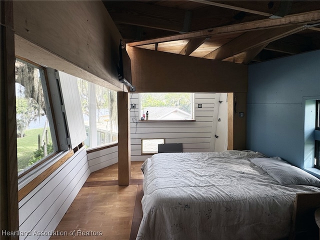 bedroom featuring hardwood / wood-style flooring and wooden walls