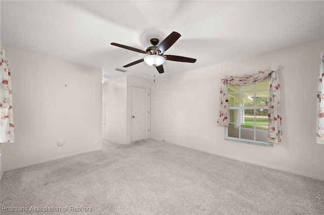 spare room featuring carpet flooring, ceiling fan, and baseboards