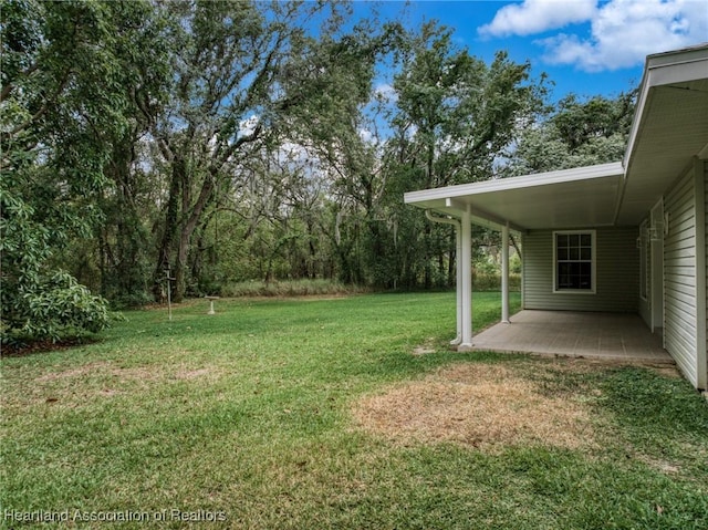 view of green lawn featuring a patio area