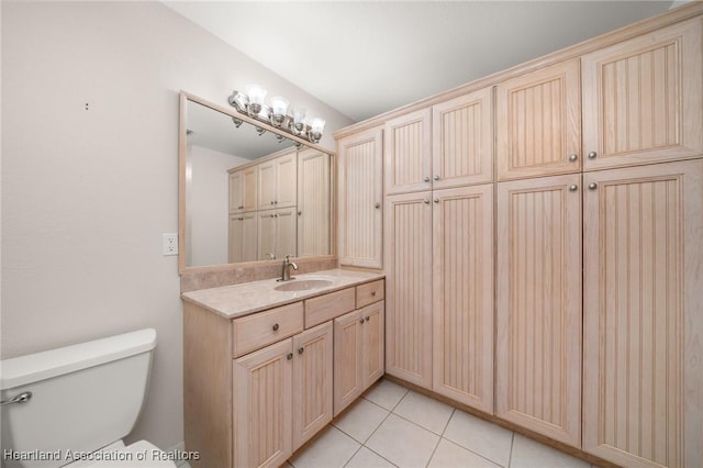 bathroom featuring toilet, tile patterned flooring, and vanity