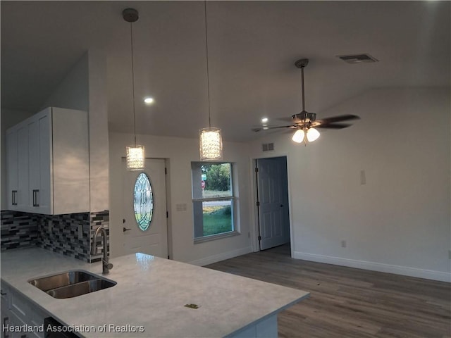 kitchen featuring white cabinetry, sink, ceiling fan, backsplash, and vaulted ceiling