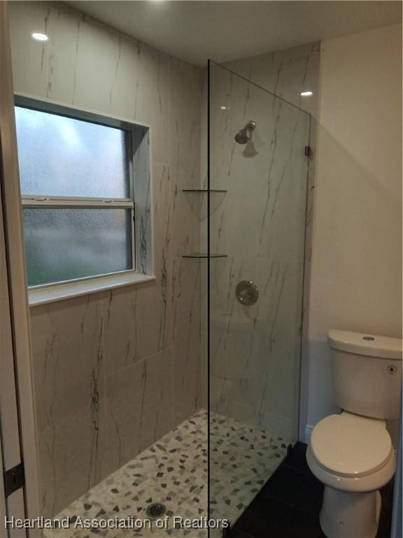 bathroom featuring toilet and tiled shower