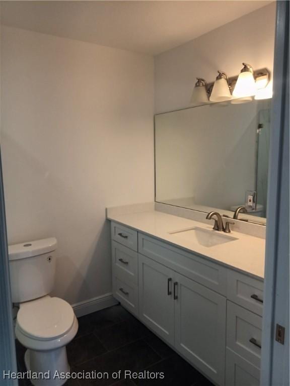 bathroom featuring tile patterned flooring, vanity, and toilet