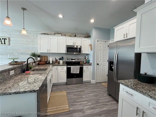 424 Branbury Ave, Lake Placid, FL 33852 - kitchen with stainless steel appliances, white cabinets, wood finished floors, dark stone countertops, and recessed lighting