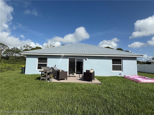 424 Branbury Ave, Lake Placid, FL 33852 - rear view of property featuring stucco siding, a lawn, a patio area, and a metal roof