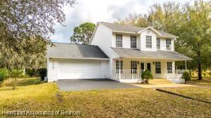11200 S Jefferson Ave, Lake Placid, FL 33852 - view of front of house featuring an attached garage, covered porch, and a front yard