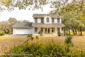 11200 S Jefferson Ave, Lake Placid, FL 33852 - traditional home featuring a porch, a garage, and driveway